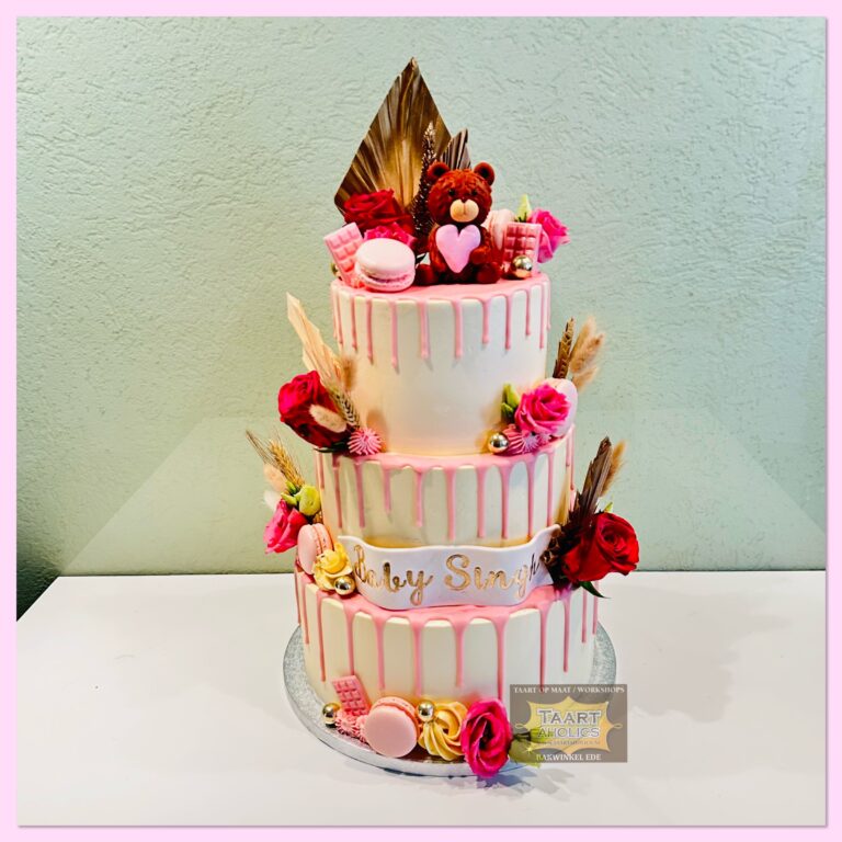 Drielaagse driptaart in wit en roze met verse rozen, macarons en een beertje bovenop
